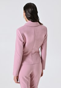 Blushroze op maat gemaakte blazer met een geknipt kraag, een getailleerde vorm en een gladde textuur. Beschikt over verticale naden en lange mouwen.