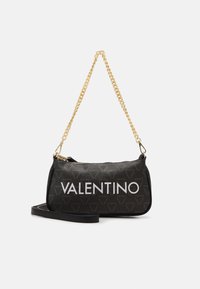 Svart läderhandväska med ett guld kedjestrap, dragkedjestängning och iögonfallande vit "VALENTINO"-logotyp. Texturerat mönster av små logotyper.