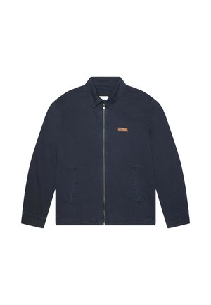 Veste en coton bleu marine avec un col pointu, fermeture éclair à l'avant et deux poches latérales ; présente un petit accent en cuir marron avec un logo.