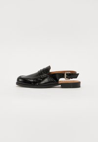 Sorte lær slingback sko med en blank finish, mokkasinstil søm, liten hæl og justerbar spenne.