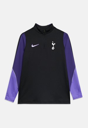 Top de sport Nike noir et violet à manches longues avec fermeture éclair quart de devant et logo du club de football Tottenham Hotspur sur la poitrine.