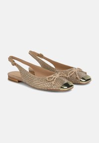 Des ballerines nues à lanières derrière, avec un bout ouvert, ornées de strass et d'un cap en métal, présentant un détail de nœud noué à l'avant.