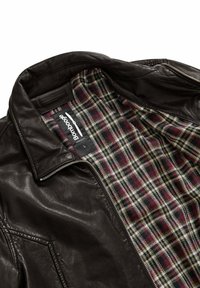 Giacca di pelle marrone con fodera interna a quadri in rosso scuro, verde e crema. Presenta una chiusura con zip anteriore e un colletto strutturato.