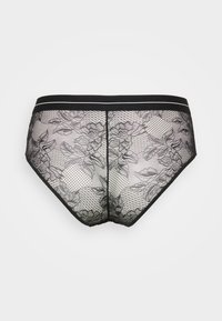 Culotte en dentelle noire mettant en valeur des motifs floraux et des panneaux en maille, avec une taille lisse noire ornée de deux bandes blanches.