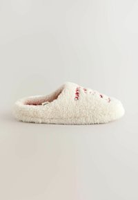 Biela nadýchaná papuča s mäkkou textúrou, s pohodlným dizajnom a červenými vyšívanými detailmi na vrchnej časti.