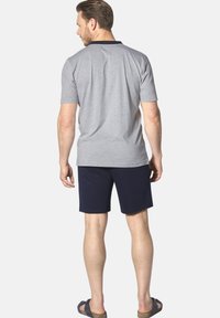 Gray short-sleeve polo shirt with navy collar, paired with navy shorts. The outfit features a casual design, suitable for warm weather.