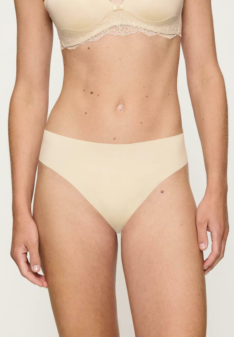 Beżowe, bezszwowe majtki bikini wykonane z miękkiego, elastycznego materiału o gładkiej fakturze i minimalistycznym designie. Brak widocznych szwów lub wzorów.