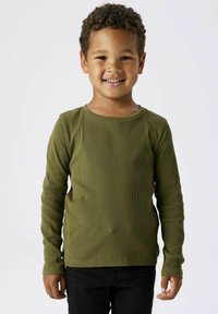 Langärmliges, geripptes Shirt in Olivgrün, weicher Textur, runder Ausschnitt, kombiniert mit dunklen Hosen, präsentiert von einem lächelnden Kind.