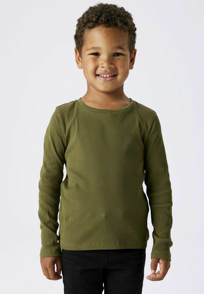 Langärmliges, geripptes Shirt in Olivgrün, weicher Textur, runder Ausschnitt, kombiniert mit dunklen Hosen, präsentiert von einem lächelnden Kind.
