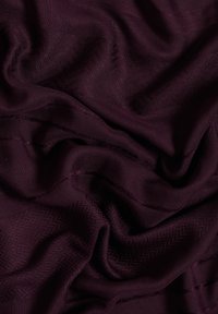 Tissu bordeaux au toucher lisse, présentant de subtils motifs en zigzag et de délicates lignes horizontales. Apparence douce et fluide.