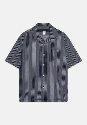 Kortermet skjorte i marineblå og hvite vertikale striper, med en skjortekrage, fem knapper og en brystlomme på venstre side.