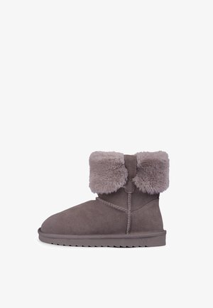 Stivale in suede grigio con risvolto in pelliccia sintetica. Punta arrotondata, suola piatta con battistrada e dettagli di cucitura discreti lungo le cuciture.