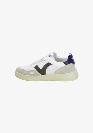 White sneaker featuring green suede accents, textured white leather upper, beige suede front, and navy heel detail with logo.