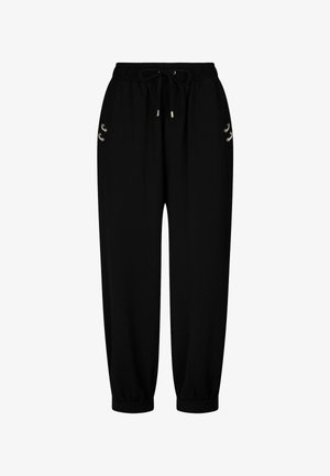 Schwarze Sweatpants mit elastischem Bund und Kordelzug. Mit goldfarbigen Details und schmal zulaufenden Bündchen an den Knöcheln. Glatte Textur.