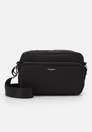 Borsa a tracolla nera con una superficie liscia e morbida, dotata di doppie tasche con zip e una larga tracolla regolabile. Logo del brand visibile sul fronte.
