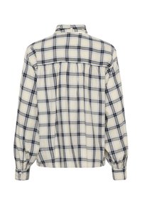 Chemise à carreaux crème avec des carrés bleus et gris, manches longues bouffantes, poignets boutonnés et un empiècement légèrement froncé.