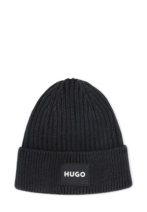 Bonnet en tricot noir avec une texture côtelée ; présente un revers et une patch logo rectangulaire avec "HUGO" en lettres blanches.