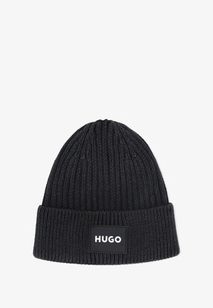 Bonnet en tricot noir avec une texture côtelée ; présente un revers et une patch logo rectangulaire avec "HUGO" en lettres blanches.