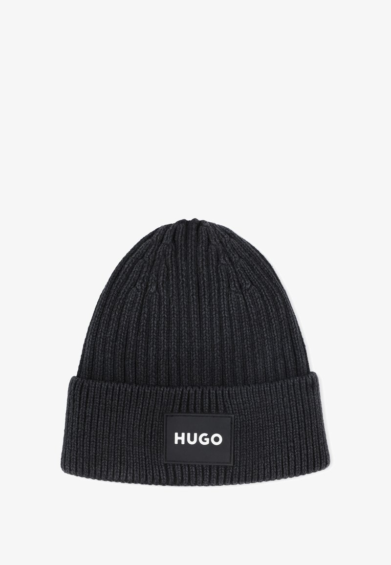 Zwarte gebreide beanie met een ribbelstructuur; heeft een manchet en een rechthoekige logopatch met "HUGO" in witte letters.