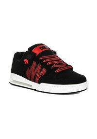 Zapatillas de skate negras con acentos rojos, que cuentan con una parte superior texturizada, cordones con patrón y una suela intermedia blanca con un bolsillo de aire visible.