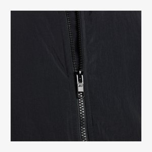 Črna lahka jakna s središnjim zadrgo s srebrnimi kovinskimi deli in teksturirano tkanino, ki kaže gladek, mat finiš.