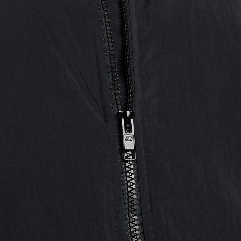 Black lightweight jacket featuring a central zipper with silver hardware and textured fabric, showcasing a smooth, matte finish.