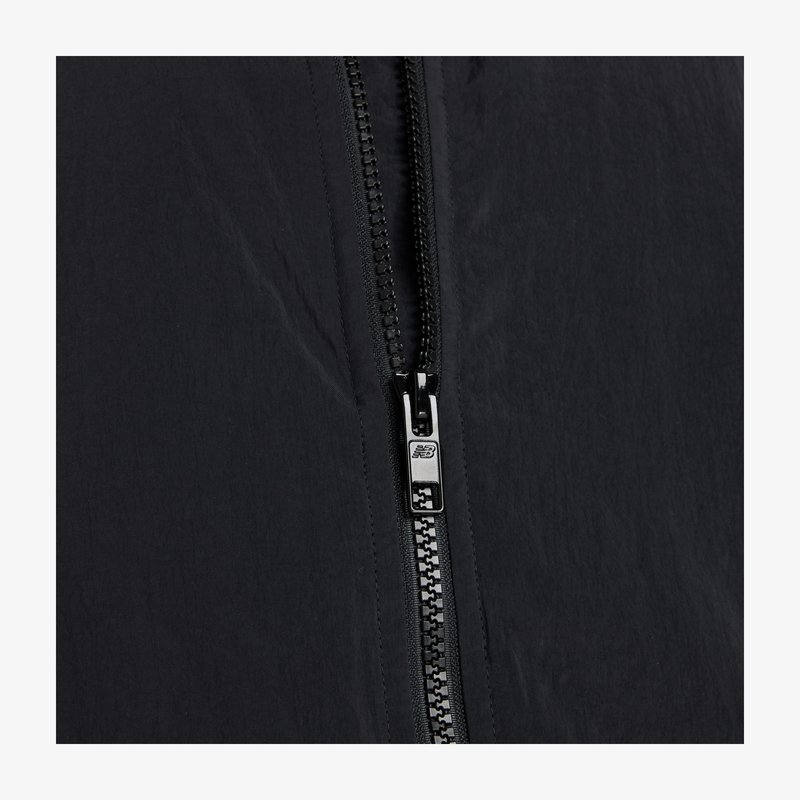 Black lightweight jacket featuring a central zipper with silver hardware and textured fabric, showcasing a smooth, matte finish.