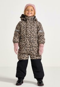 Tuta in stampa leopardata con cappuccio, con pantaloni neri, strisce grigie e guanti e cappello lavorati a maglia rosa, realizzato in materiale isolante.