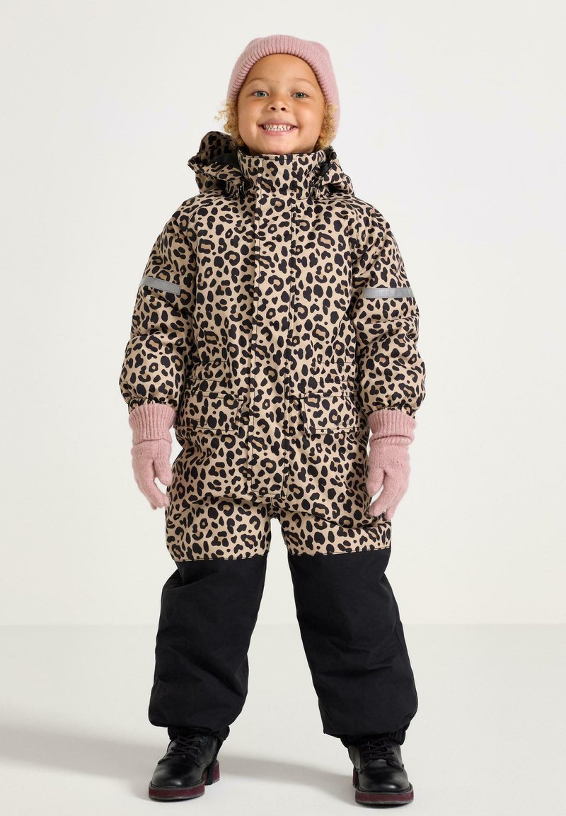 Tuta in stampa leopardata con cappuccio, con pantaloni neri, strisce grigie e guanti e cappello lavorati a maglia rosa, realizzato in materiale isolante.