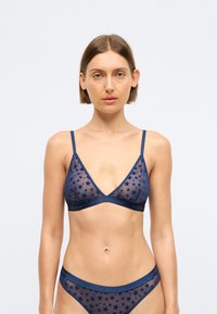 Tume sinine bralette ja sobivad aluspüksid, mis on valmistatud läbipaistvast materjalist, tähistaevaga mustriga, reguleeritavate rihmadega ja logoga vöökoht.