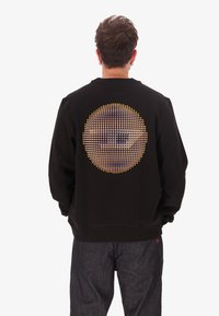 Felpa nera con una grafica rotonda multicolore di punti che formano una sfera sul retro. Maniche e colletto a coste, vestibilità morbida.