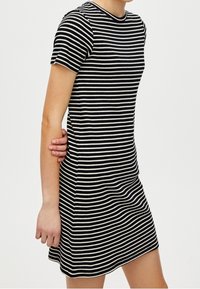 Gestreiftes Kleid mit kurzen Ärmeln, Rundhalsausschnitt und taillierter Passform. Es wechselt zwischen schwarzen und cremefarbenen horizontalen Streifen.