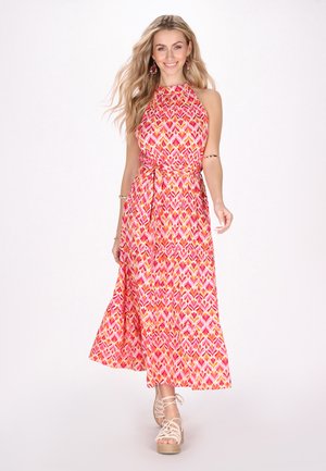 Maxikjole med halterneck, levende pink og orange geometrisk mønster og en knyttet talje. Bærer tan espadrille wedges.