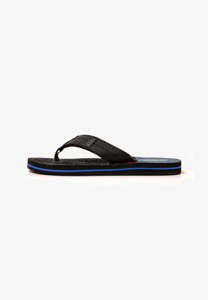 Sandalia tipo flip-flop negra con plantilla texturizada, raya azul en el borde de la suela y tira acolchada con detalle de logo circular.