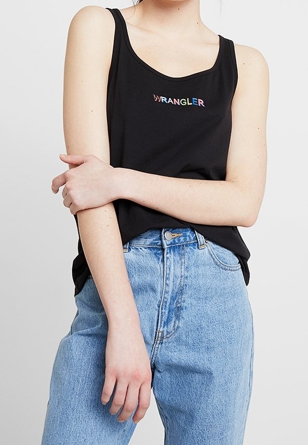 Svart linne med regnbågsfärgad "WRANGLER"-logotyp, med rundad halsringning. Matchas med höga ljusblå jeans.