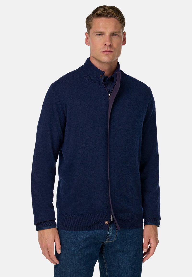 Marineblauer Reißverschluss-Pullover mit hohem Kragen, strukturiertem Stoff und gerippten Bündchen und Saum. Verfügt über einen kontrastierenden Reißverschluss und Knopfdetail.