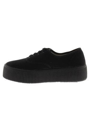 Zapatillas de lona negras con una suela de goma gruesa y estriada, punta redonda, cordones con seis ojetes y sutiles detalles de costura.
