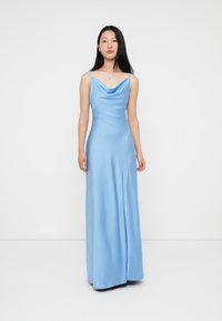Vestido maxi em cetim azul claro com decote em cowl, alças finas e uma silhueta fluida. Textura suave com um caimento elegante.