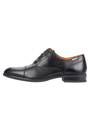 Zapato de vestir de cuero negro con acabado suave, punta redonda, diseño de cordones con seis ojales, tacón bajo apilado y un sutil detalle en el lateral.
