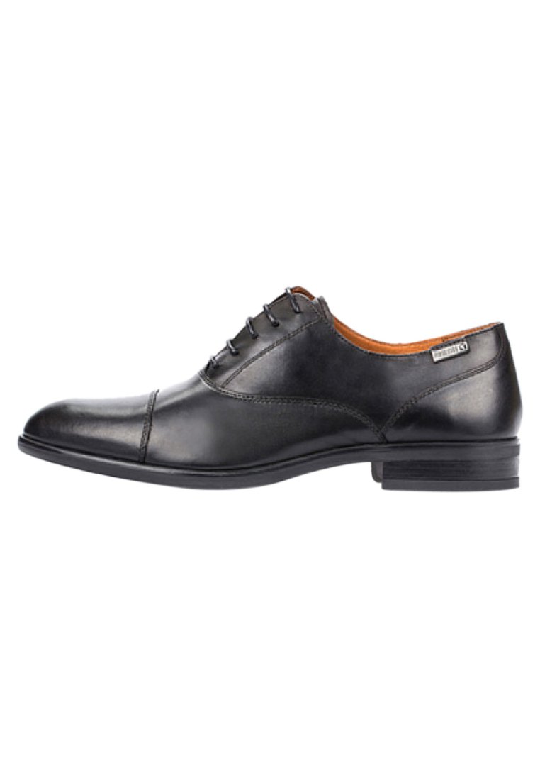 Zapato de vestir de cuero negro con acabado suave, punta redonda, diseño de cordones con seis ojales, tacón bajo apilado y un sutil detalle en el lateral.