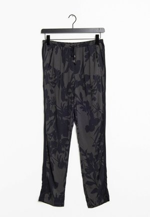 Pantalon gris foncé avec motifs floraux noirs, taille élastique et poches latérales suspendu à un cintre noir sur fond blanc.