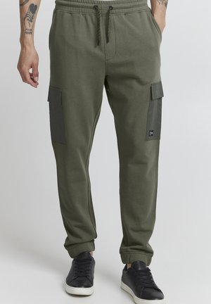 Oliven grønne joggers med en afslappet pasform, elastisk talje og sidelommer med cargo-design, der har en mørk panel. Stoffet er blødt med en glat overflade.