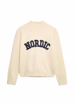 Crème trui met een hoge hals, geribbelde manchetten en zoom. Heeft grote marineblauwe "NORDIC" letters over de voorkant. Zachte structuur.