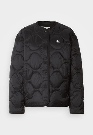 Svart puffjacka med ett kviltat mönster, rund krage, tryckknappar och en logotyp på bröstet. Slät, glänsande tyg och vadderad textur.