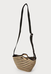 Sac en paille tissé avec un motif rayé noir et naturel, présentant une forme courbée, des poignées supérieures doubles et une sangle noire réglable.