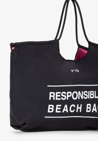 Borsa da spiaggia in tessuto nero con testo bianco "Borsa da Spiaggia Responsabile." Presenta spallacci arrotondati e una fodera interna a contrasto di colore rosa.