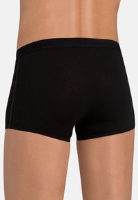 Boxer shorts neri realizzati in tessuto liscio, con una vita ampia decorata da testo, gambe corte e dettagli di cucitura minimi.