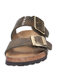 Sandales à imprimé serpent marron et vert avec deux sangles ajustables, boucles dorées et semelle en liège. Semelle en caoutchouc pour une meilleure adhérence.
