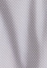 Tessuto a fantasia con una base grigio chiaro e un design geometrico ripetitivo. La texture sembra liscia con una leggera lucentezza.