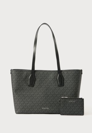 Černá taška přes rameno vyrobená z texturovaného materiálu, s vyraženým vzorem loga, dvojitými uchy a odpovídajícím pouzdrem na karty. Hladké kožené akcenty.